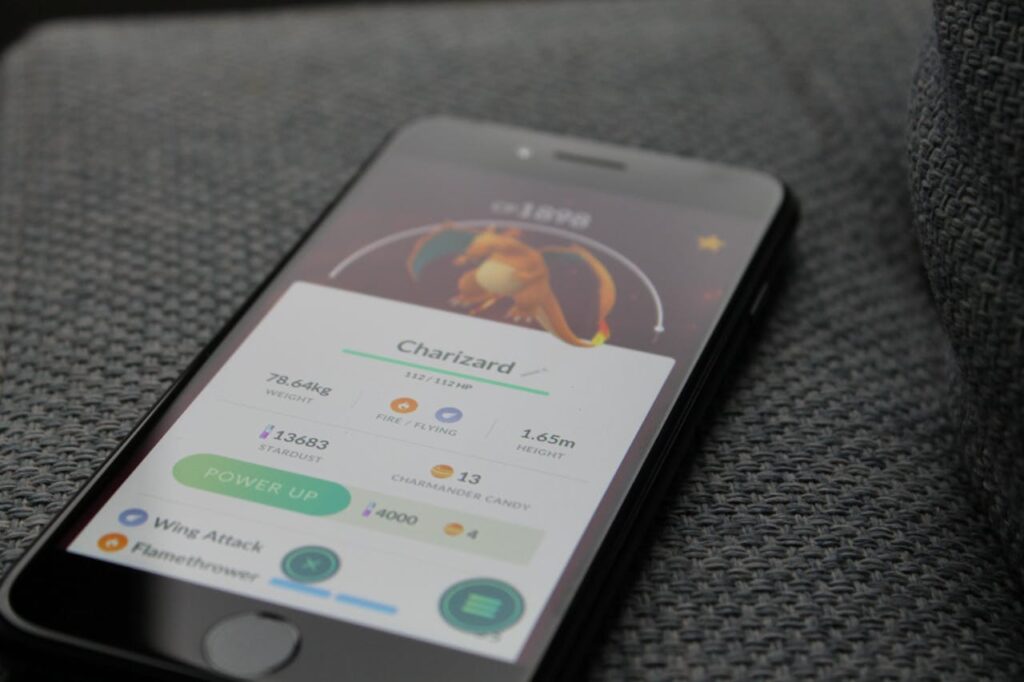 Smartphone displaying Pokémon GO screen with Charizard, highlighting gaming technology.